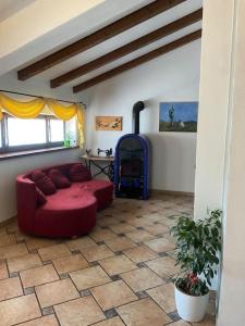 a living room with a red couch and a fireplace at CASA FILAFERRO - VIA LOMBARDIA 4 MOGGIO UDINESE in Moggio Udinese