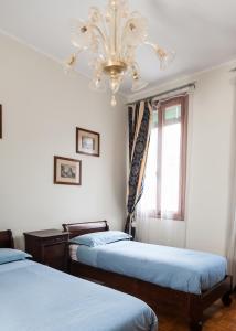 a bedroom with two beds and a chandelier at Corte Stupenda in Venice