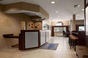 a restaurant lobby with a counter and some chairs at Microtel Inn & Suites by Wyndham St Clairsville - Wheeling in Saint Clairsville