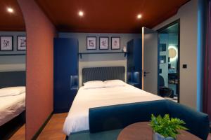 a blue bedroom with a bed and a table at Hotel Nicolaas Witsen in Amsterdam