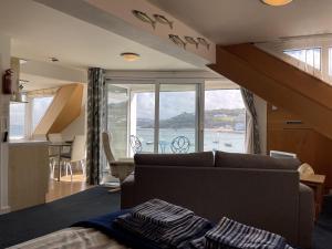 a living room with a couch and a large window at Crows Nest - panoramic views of St Ives harbour in St Ives