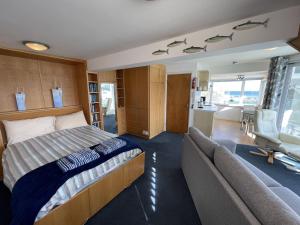 a bedroom with a bed and a couch at Crows Nest - panoramic views of St Ives harbour in St Ives