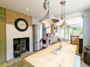 a kitchen with a fireplace and a clock on the wall at La Maison De La Mer, Worthing in Worthing