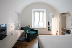 a bedroom with a bed and a desk and a couch at Le Stanze Del Savonarola in Ferrara