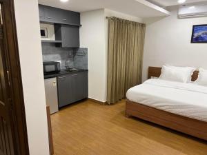 Habitación pequeña con cama y cocina en Palladium Luxury Suites Financial District Unit I, en Hyderabad