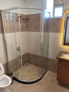 a shower stall in a bathroom with a toilet at Palladium Luxury Suites Financial District Unit I in Hyderabad