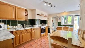 a kitchen with wooden cabinets and a wooden table at 3 Bedroom Character Townhouse on Edge of Blackdown Hills in Wellington