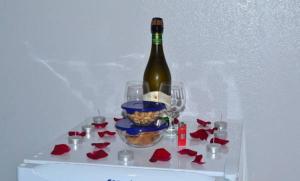 a bottle of wine sitting on a shelf with red roses at pousada dos sonhos in Pirenópolis
