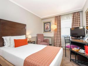 a hotel room with a bed and a television at Mercure Johannesburg Randburg in Johannesburg