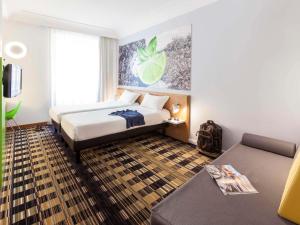 um quarto de hotel com uma cama e um sofá em Ibis Styles Napoli Garibaldi em Nápoles