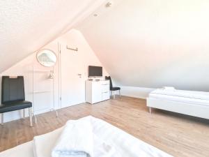 a white room with a bed and a desk at Möwenkieker in Greetsiel