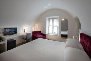 - une chambre avec un lit, un bureau et une chaise dans l'établissement Le Stanze Del Savonarola, à Ferrare