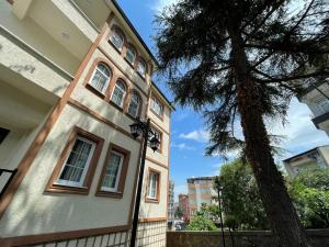 a building with a tree in front of it at CLOUDS Atapark in Soğuksu