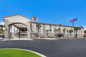 a hotel with a parking lot in front of it at Sleep Inn & Suites in Valdosta