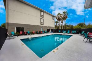 a swimming pool with colorful chairs and a building at Sleep Inn & Suites in Valdosta