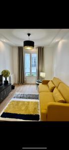 パリにあるCharming parisian apartmentのリビングルーム(黄色のソファ、窓付)