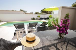 una mesa con un sombrero de paja encima de la piscina en Apartmani Leona, en Bibinje