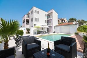 a villa with a swimming pool and a house at Apartmani Leona in Bibinje