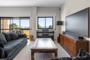 ein Wohnzimmer mit einem Sofa und einem Flachbild-TV in der Unterkunft Cascais by the Sea in Estoril