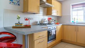 una cucina con armadi in legno e piano cottura. di Spacious & charming apartment by the New Forest a Ringwood