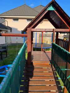 a wooden ramp leading to a playground with a slide at Spa & Wellness Hotel Orchidea in Veľký Meder