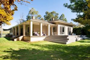 a small house with a porch and a lawn at Woodlands - Vineyard setting in Penwortham