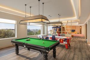 una stanza con tavolo da biliardo e una sala giochi con finestre di Courtyard by Marriott Shillong a Shillong
