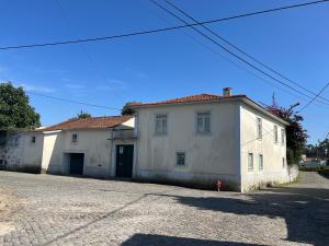 uma casa branca com um telhado vermelho numa rua em Casa do Sete em Vilar do Pinheiro