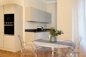 eine Küche mit einem Tisch und Stühlen mit einer Vase darauf in der Unterkunft Castore Apartment in Mailand
