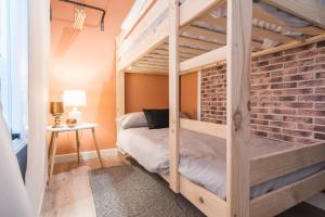 Litera en habitación con pared de ladrillo en Mushara Apartamento Turístico, en La Cumbre