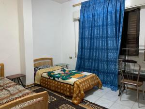 a bedroom with two beds and a blue curtain at PALM Home in Amman