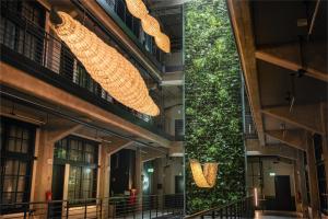 two views of a building with a green wall at MONTOWNIA Lofts & Experience in Gdańsk