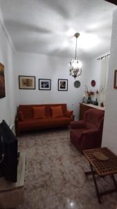 a living room with two red couches and a chandelier at Casa Rural de la Parra in La Adrada