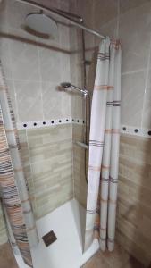 a shower in a bathroom with a shower curtain at Casa Rural de la Parra in La Adrada