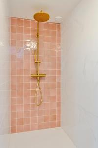 uma casa de banho com um chuveiro com azulejos cor-de-rosa em Enschede81 em Enschede