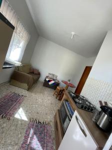 a kitchen and living room with a couch and a stove at Casa na canastra DUDU in São Roque de Minas