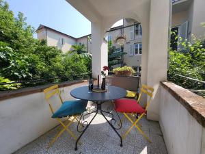 einen Tisch und vier Stühle auf einem Balkon mit einem Tisch in der Unterkunft Le Melodie Di Lucca in Lucca