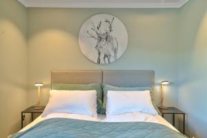 a bed with two pillows and a clock on the wall at Lyngen Experience Lodge in Nord-Lenangen