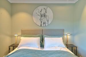 ein Bett mit zwei Kissen und einer Uhr an der Wand in der Unterkunft Lyngen Experience Lodge in Nord-Lenangen