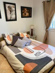 uma cama com um cobertor colorido num quarto em Rez de Jardin Villa Cagnes Sur Mer. em Cagnes-sur-Mer