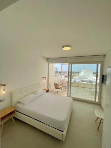 - une chambre blanche avec un lit et un balcon dans l'établissement TS Residence, à Gallipoli