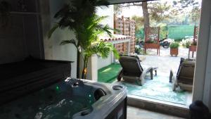 uma casa de banho com uma banheira com uma palmeira em Au Cœur de l'Eze avec JACUZZI em La Tour-dʼAigues