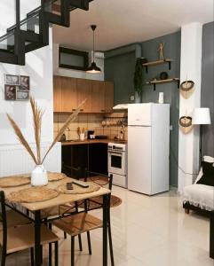 uma cozinha com uma mesa e um frigorífico branco em Io the cosy home Plomari em Plomari