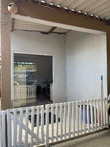 a house with a white fence and a sliding glass door at Casa na canastra DUDU in São Roque de Minas +5 photos