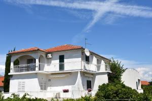 a white house with a balcony on top of it at Apartments Silvija near Luke beach in Murter