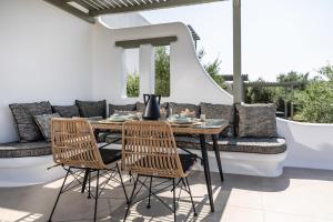 a patio with a table and chairs and a couch at Arsenis Luxury Villas in Plaka