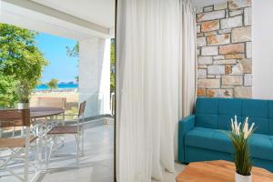 a living room with a blue couch and a table at Brothers Studios & Suites in Skala Potamias