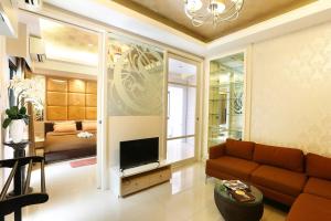 een woonkamer met een bank en een tv bij The Luxury Residence in Songkhla