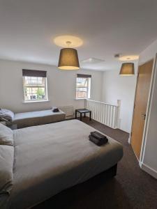 a bedroom with two beds and two windows at Self contained town house in Mexborough in Mexborough