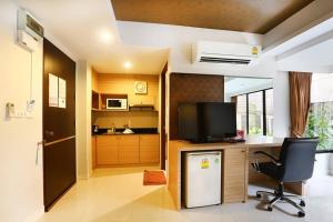 a kitchen with a desk with a television and a chair at The Luxury Residence in Songkhla
